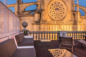 A rooftop terrace with seating, a decorative urn, and a sign reading "Puerta del Sol".