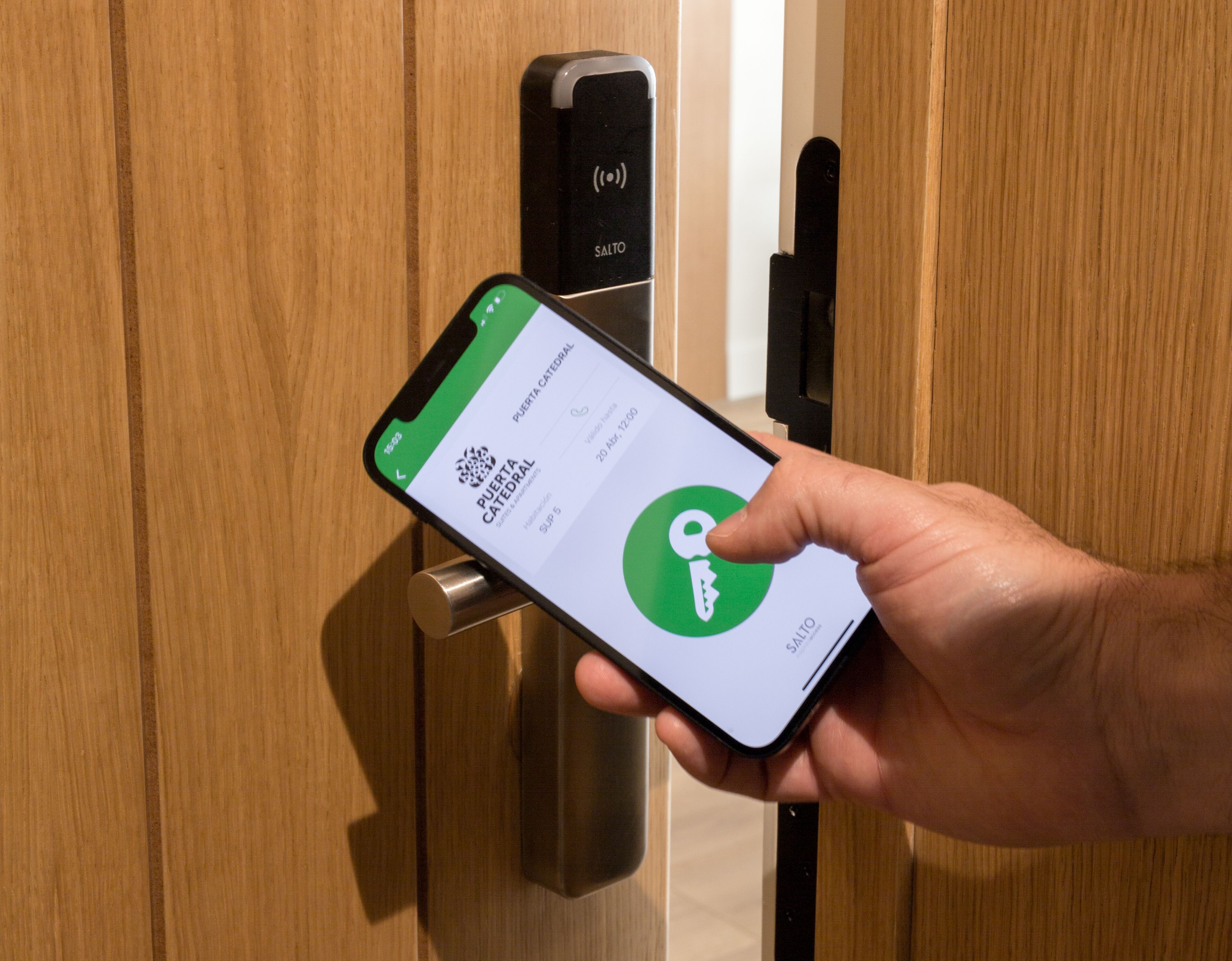 Una mano sosteniendo un teléfono inteligente que muestra una aplicación para Puerta Catedral.