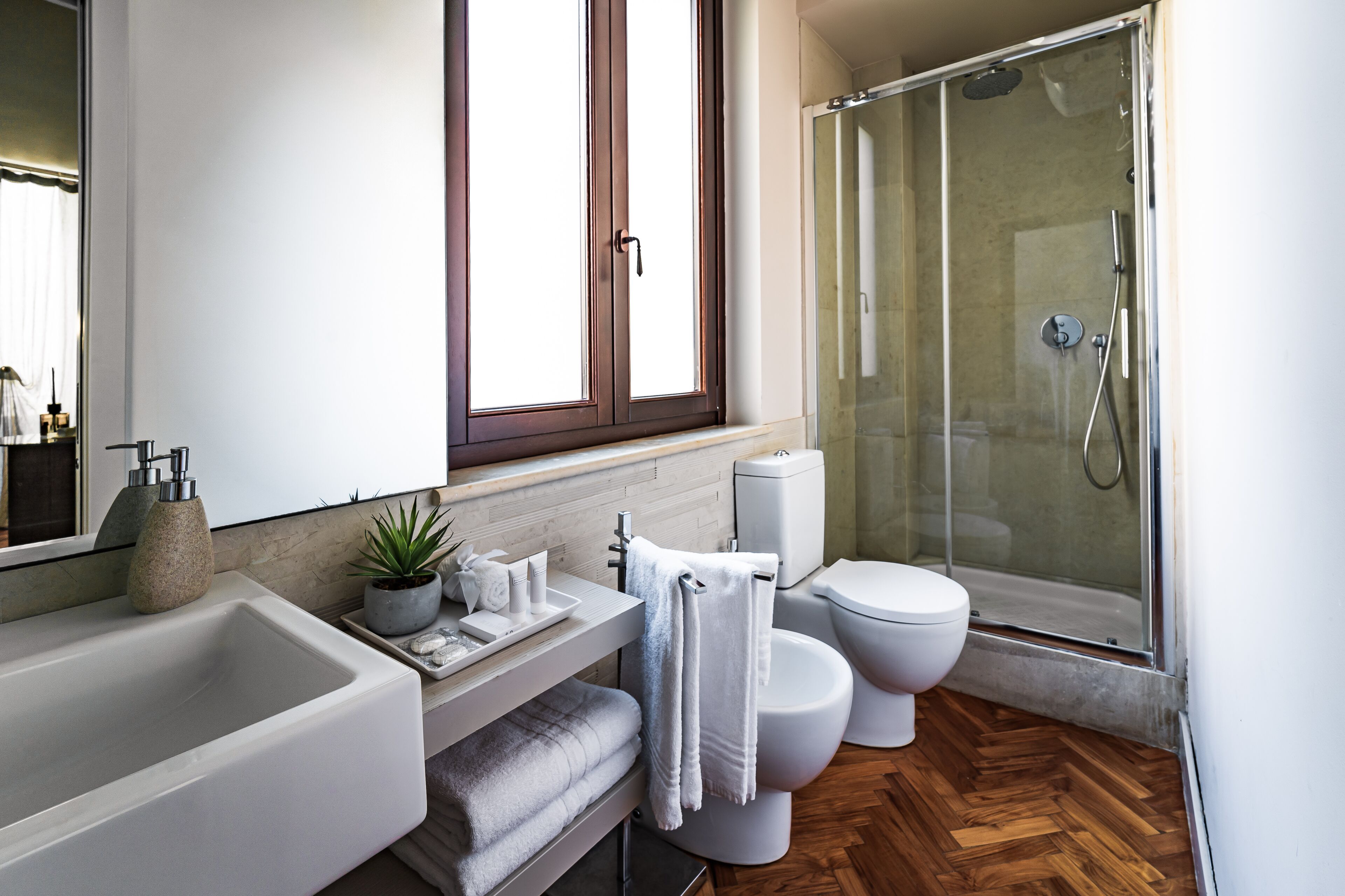 A modern bathroom with a large bathtub, a toilet, and a glass-enclosed shower.