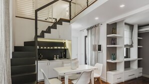 A modern kitchen with a dining area, a staircase, and built-in shelving. - Ferrini Home - Via Monte Sant'Agata (Catania)