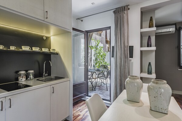 A modern kitchen with a built-in stove, a sink, and a dining area with a table and chairs.