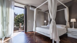 A modern bedroom with a four-poster bed, a nightstand, and a view of the outdoors. - Ferrini Home - Via Monte Sant'Agata (Catania)