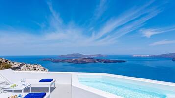A white infinity pool with a clear view of the sea and islands.