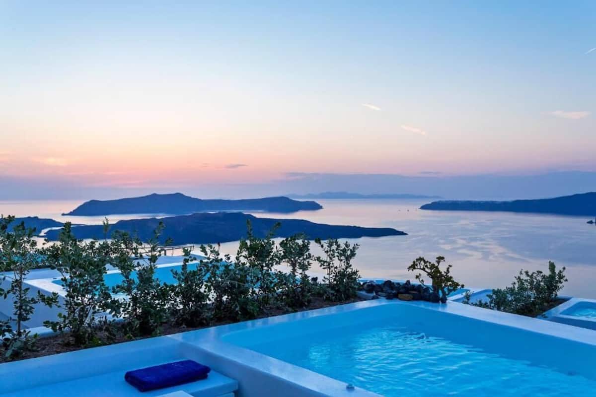 Una piscina infinita con vistas al mar y a las islas al atardecer.
