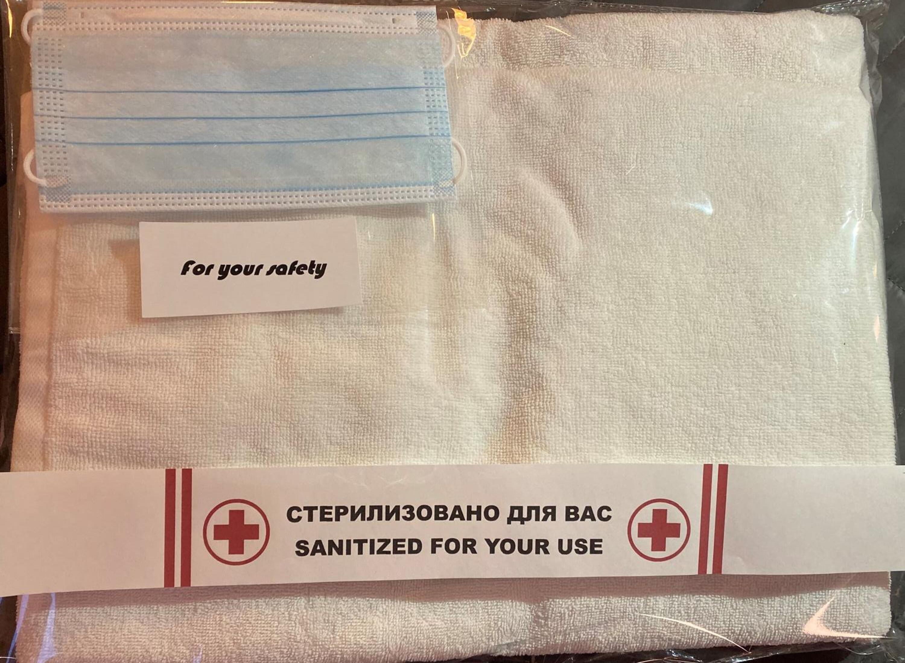 Un paquete que contiene una mascarilla y una nota que dice 'por tu seguridad'.