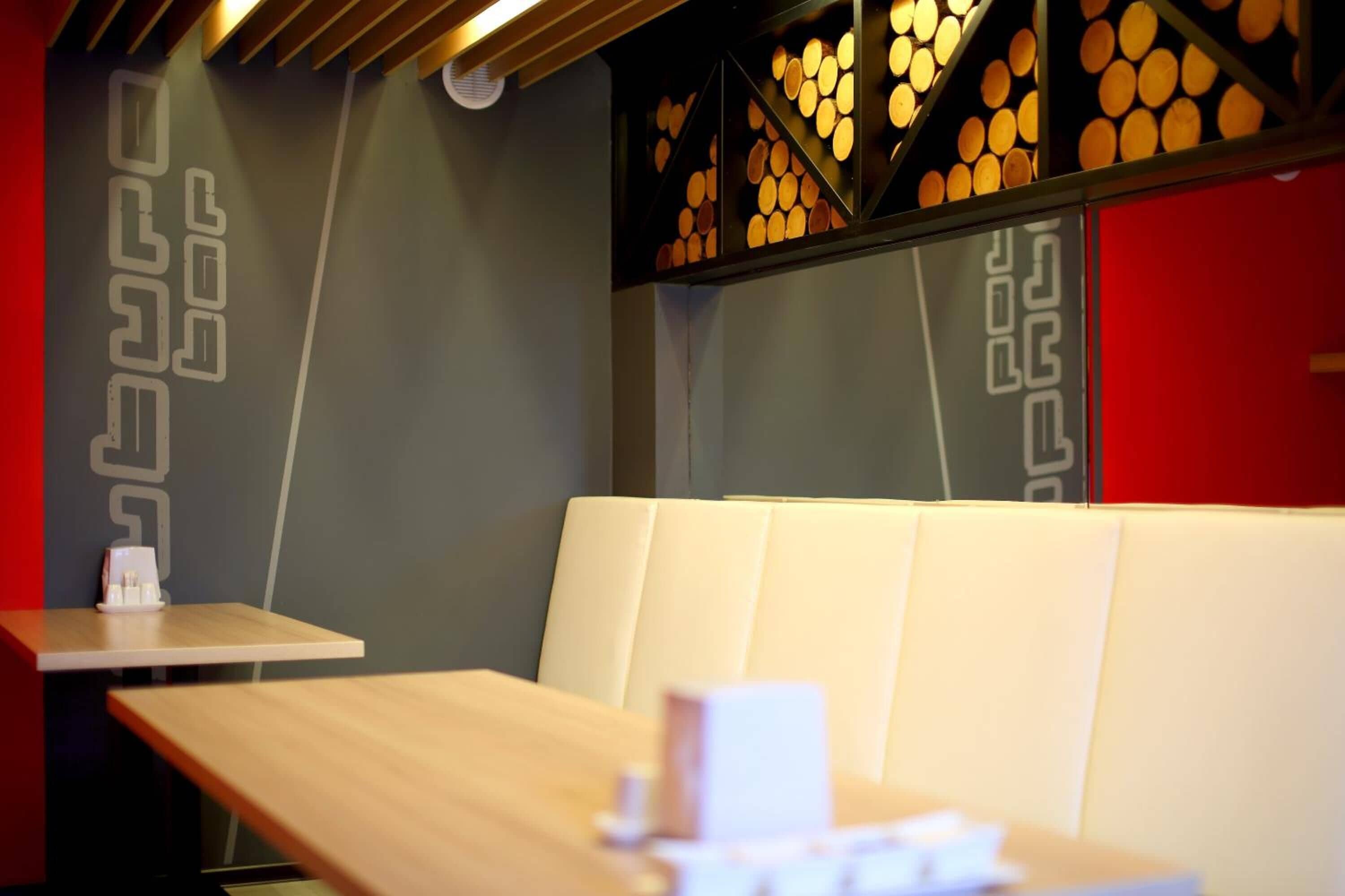 Een modern interieur met een houten tafel en een witte, beklede bank.