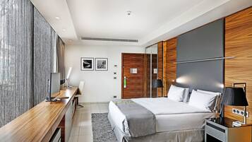 Ein modernes Schlafzimmer mit einem großen Bett, einem Schreibtisch und einem Kleiderschrank.