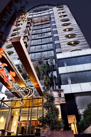 A modern hotel with a prominent 'stone55' sign, multiple balconies with plants, and a glass facade. - Warwick Stone 55 Hotel (Zalqa)