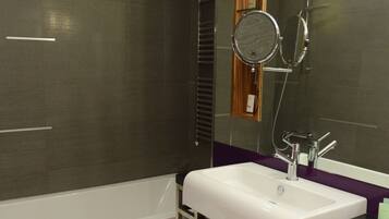 Een moderne badkamer met een bad, een wastafel en een toilet.