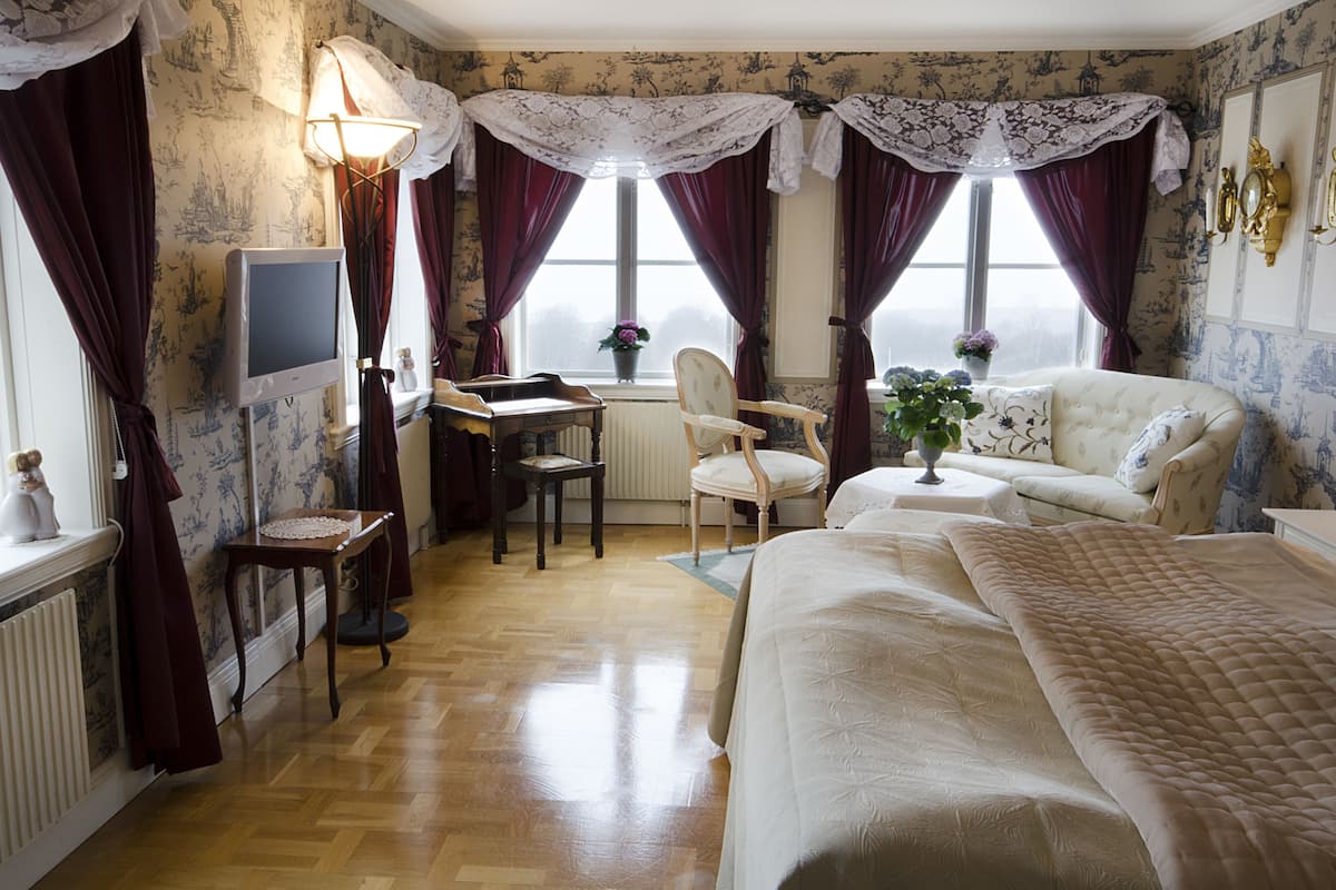 Una habitación de hotel con cama, escritorio, silla y sofá.