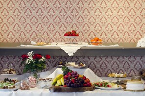 A buffet table with various food items and a decorative centerpiece.