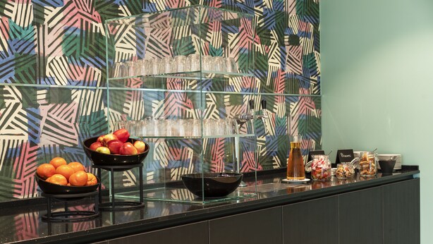A buffet area with glass shelves holding fruits, a bowl of apples, and various condiments. - Thon Hotel Verdal (Verdal)