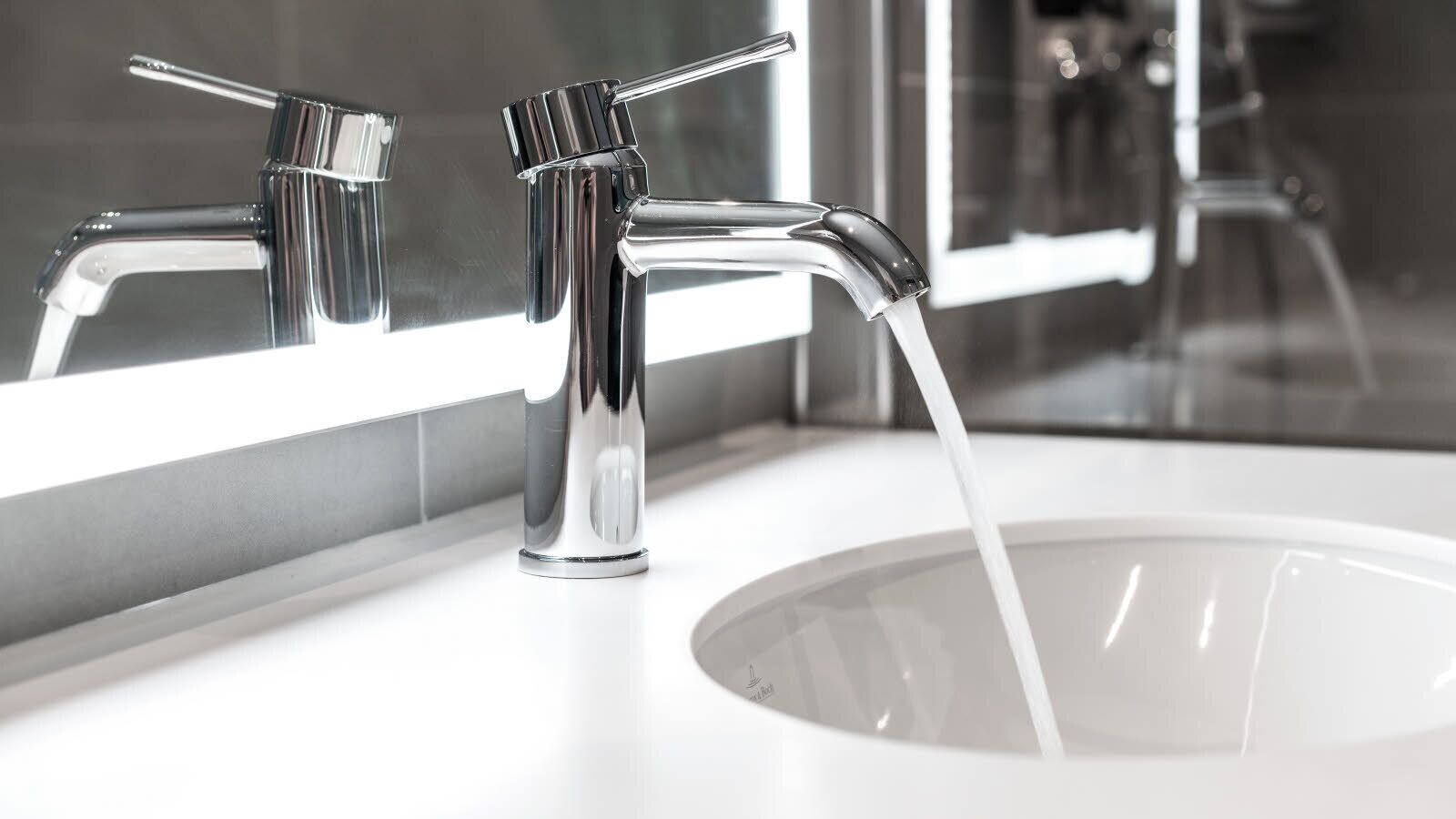 A modern bathroom with a chrome faucet and a white sink.