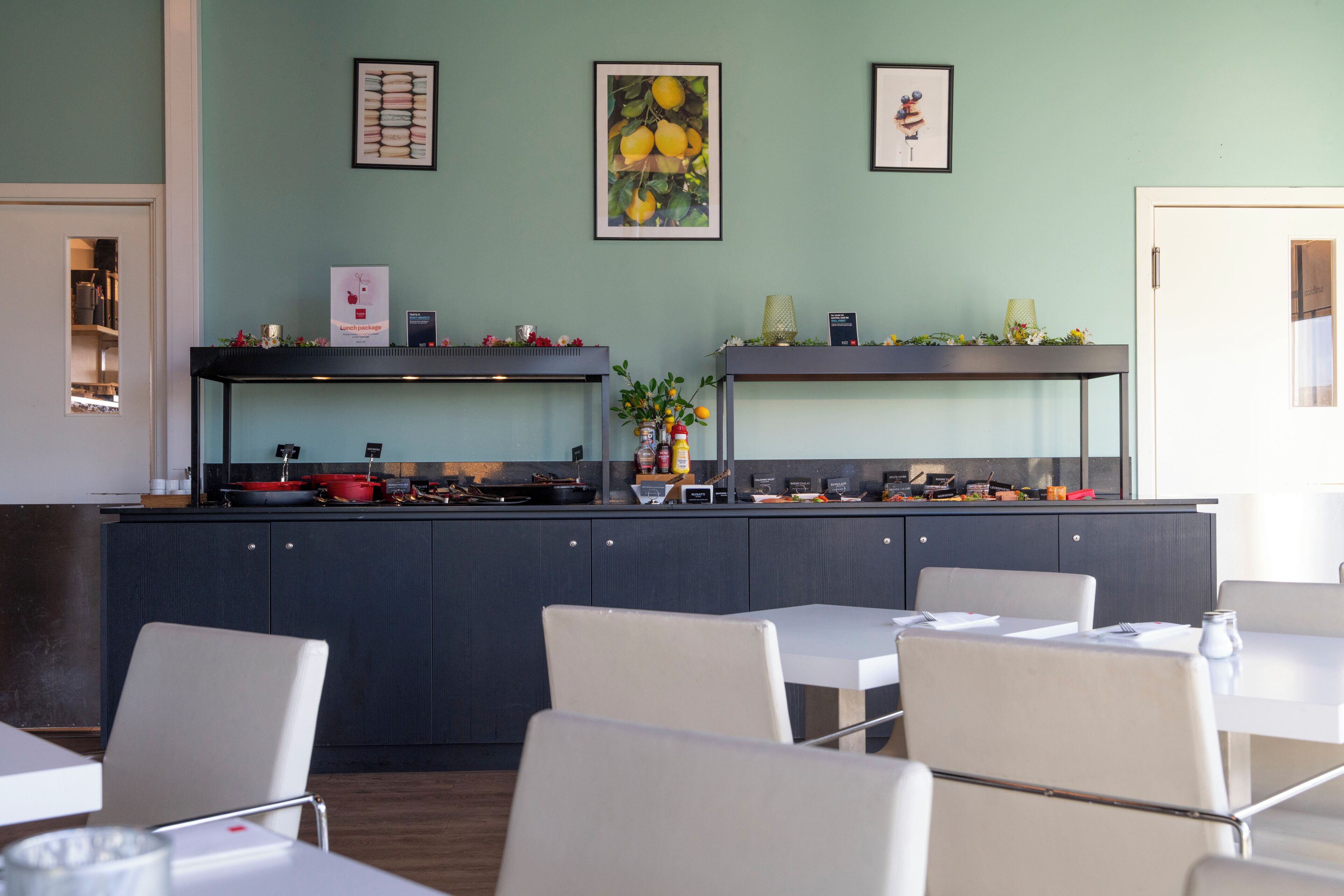A modern restaurant with a kitchen counter, dining tables, and chairs.