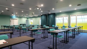 A classroom with rows of desks and chairs, a projector, and large windows with curtains. - Thon Hotel Verdal (Verdal)