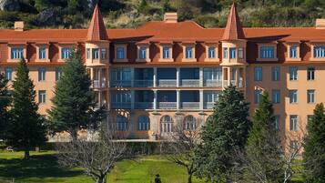 A multi-story hotel with a symmetrical facade, balconies, and a central courtyard.