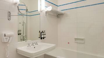 A bathroom with a sink, mirror, towel rack, and a glass shower enclosure.
