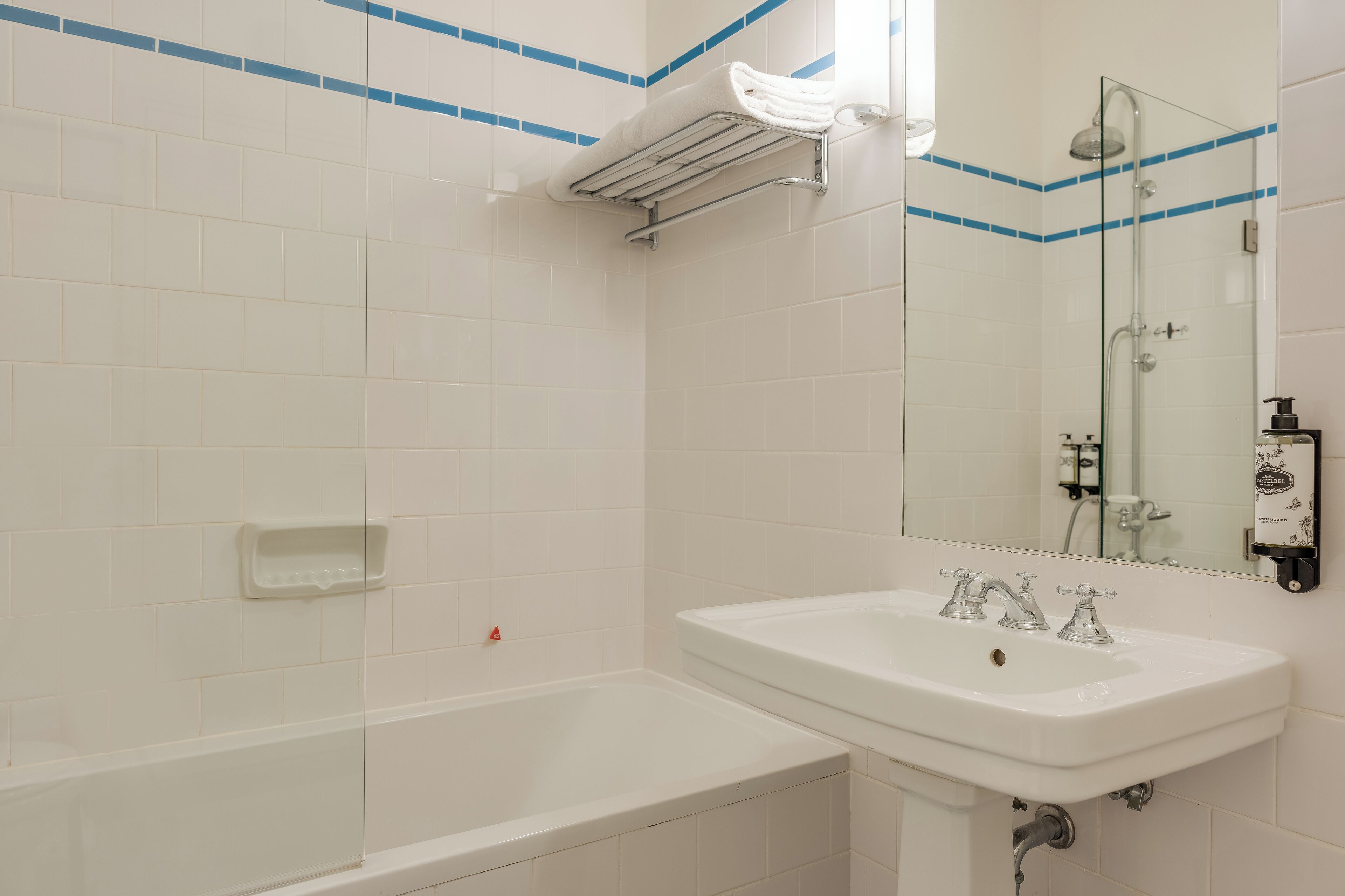 Ein Badezimmer mit Waschbecken, Duschkabine und Handtuchhalter.