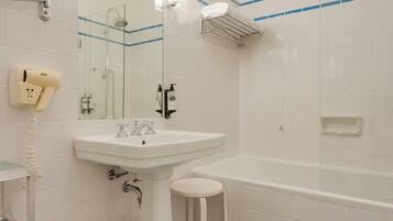 A bathroom with a white sink, a mirror, a handheld hair dryer, a shower, and a bathtub.