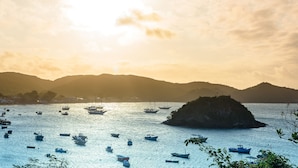 A coastal scene with boats on the water and a pier extending into the sea. - Abracadabra Boutique Hotel (Búzios)