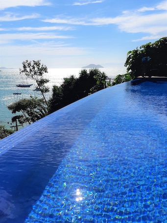 Una piscina al aire libre, sillones reclinables de piscina
