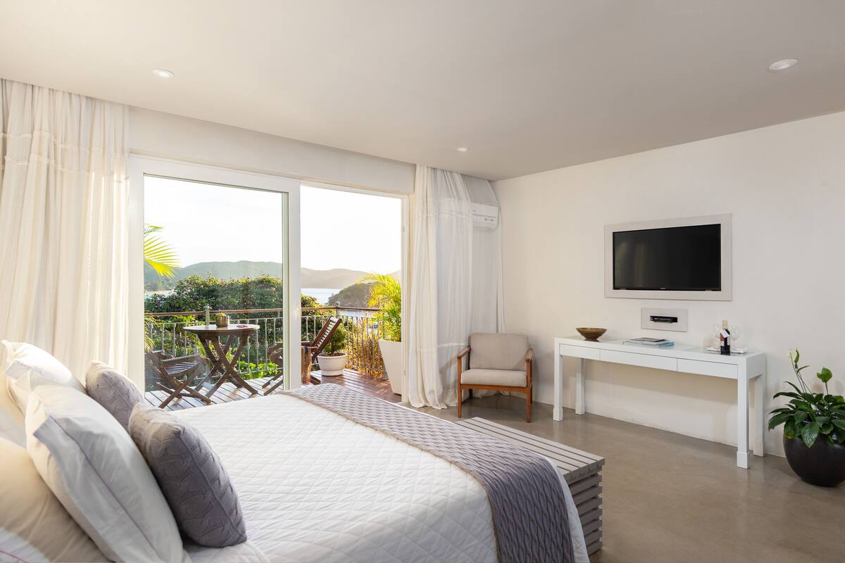 Un dormitorio moderno con una cama grande, un escritorio y un televisor.