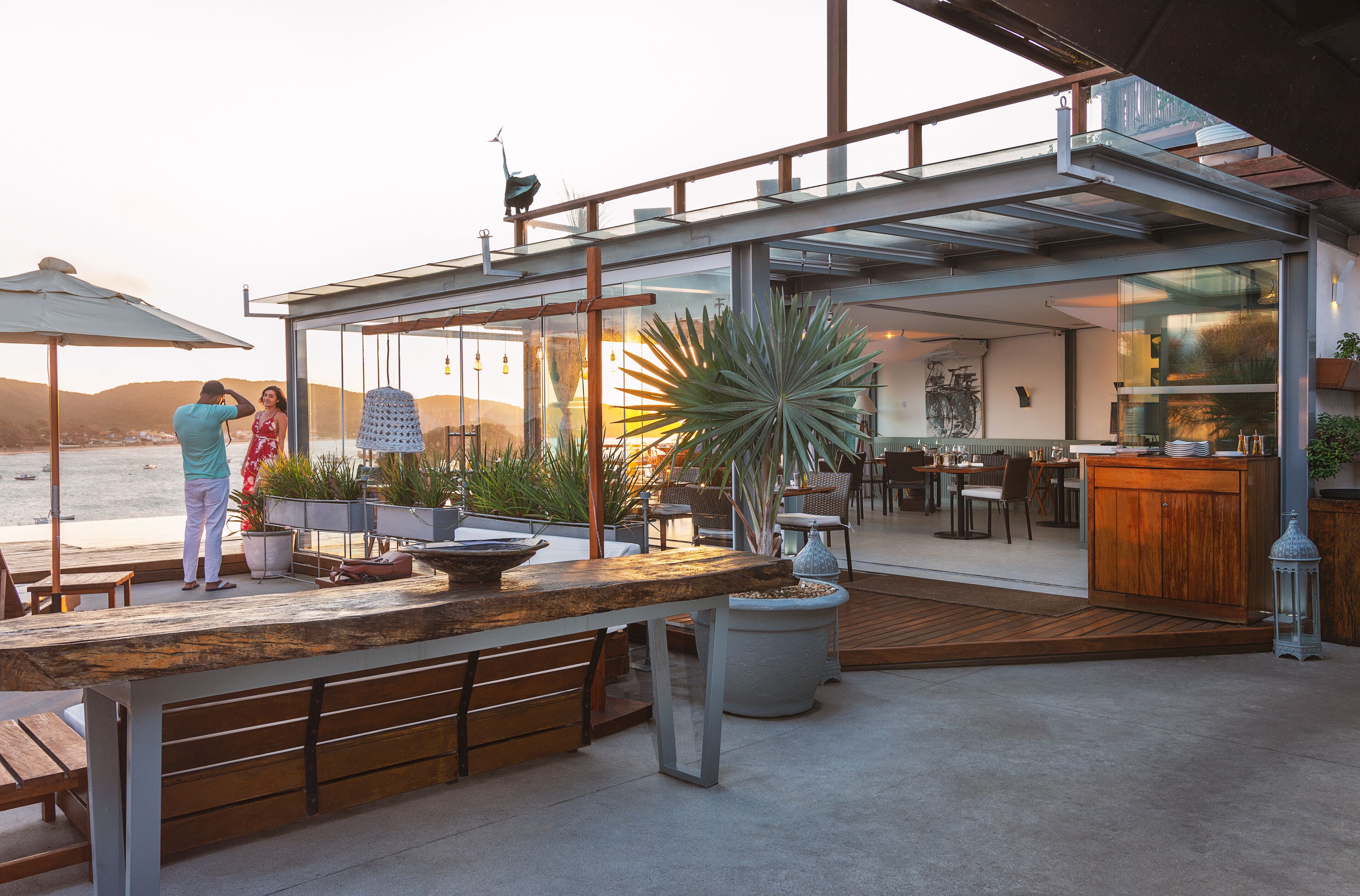En udendørs patio med træterrasse, siddepladser og en bar.