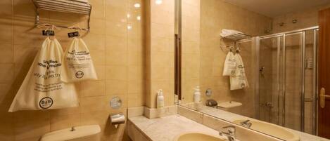 Une salle de bain équipée de toilettes, d’un lavabo, d’un miroir et d’une douche.