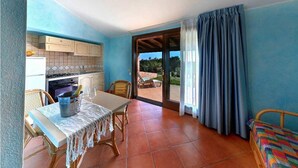 A compact room with a kitchen, dining area, and a balcony with a view. - Il Borgo di Porto Corallo (Villaputzu)
