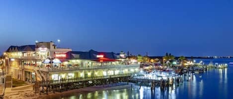 A waterfront hotel with multiple dining areas and a pier extending into the water.