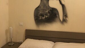 A bedroom with a bed, a nightstand, and a wall mural. - La Maison dei Miracoli (Pisa)