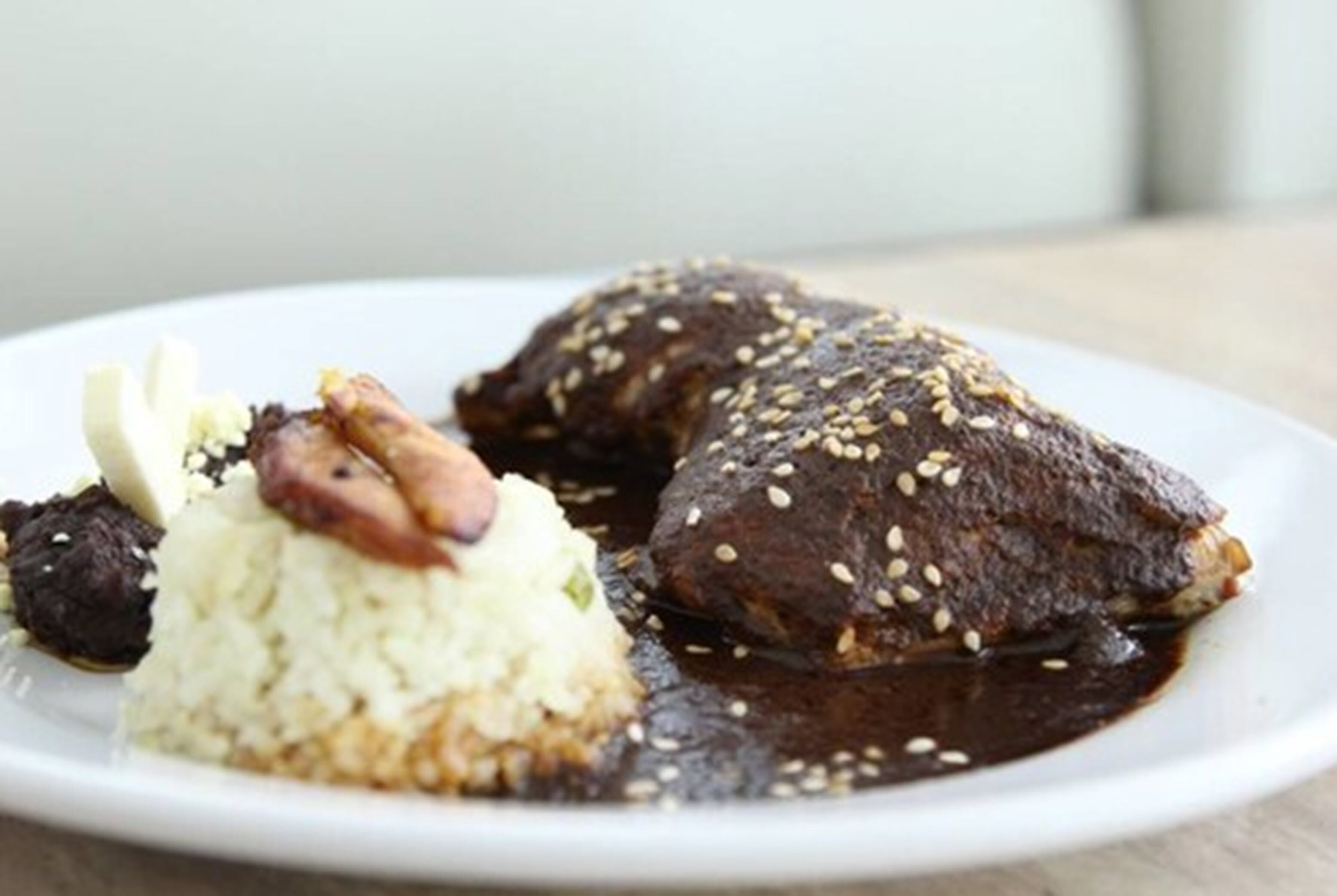 Un plato con dos rebanadas de pan cubiertas de semillas de sésamo y una guarnición de arroz.