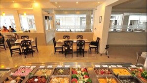 A buffet area with multiple food stations and dining tables with chairs. - Hotel Maria Eugenia Tuxtla Gutierrez (Tuxtla Gutierrez)