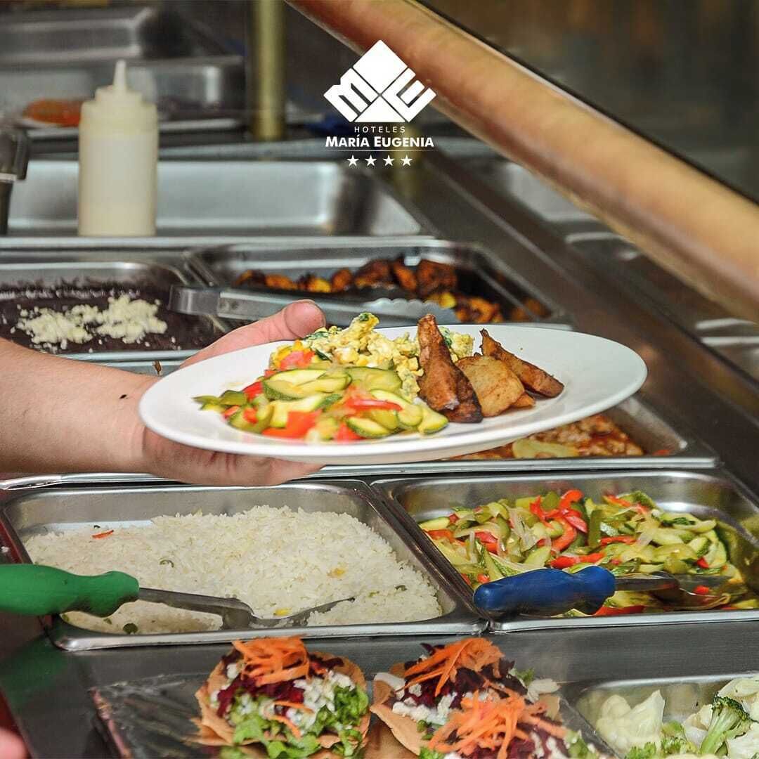 A buffet with various food options including rice, salads, and grilled chicken.