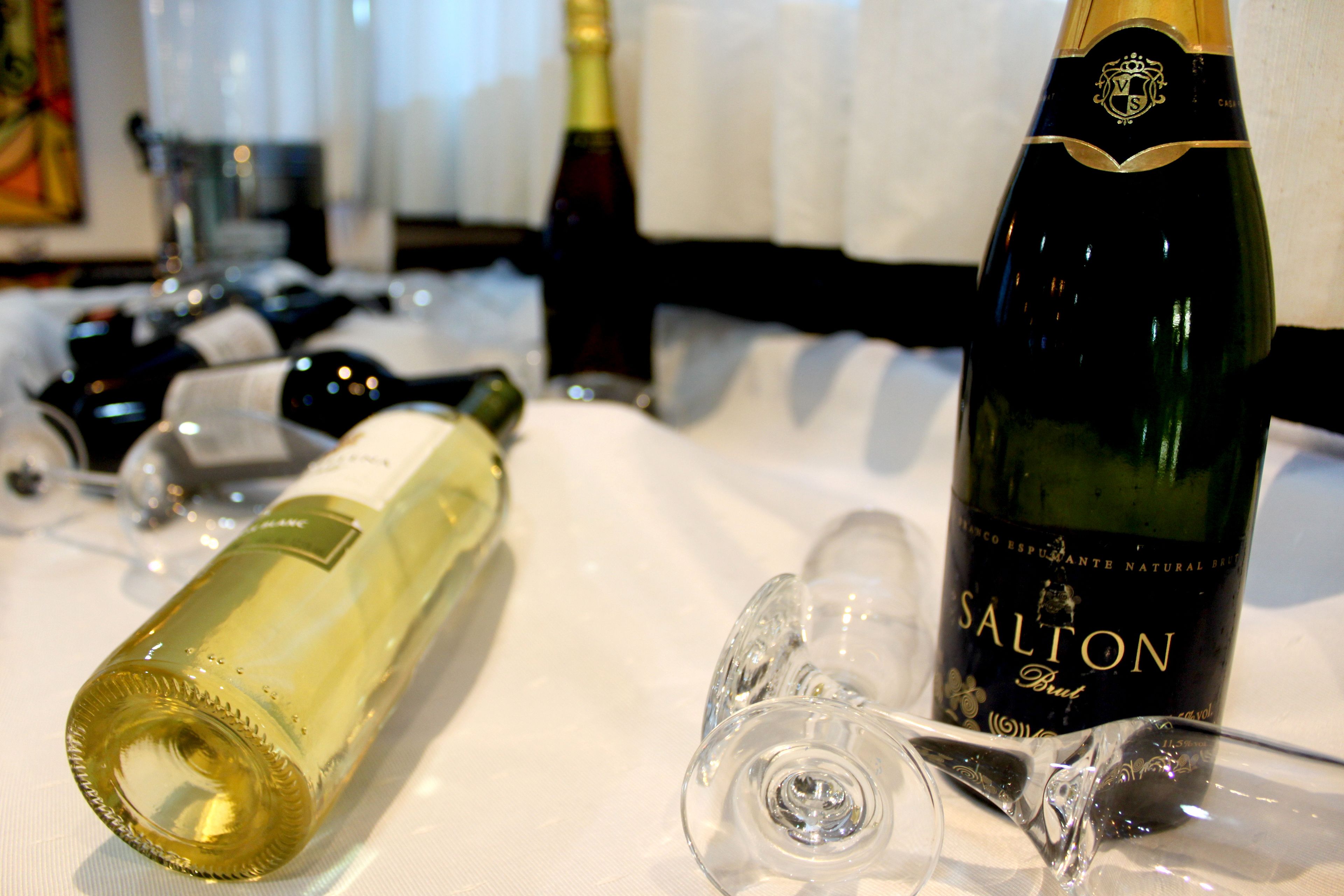 Una mesa con botellas de vino y copas.