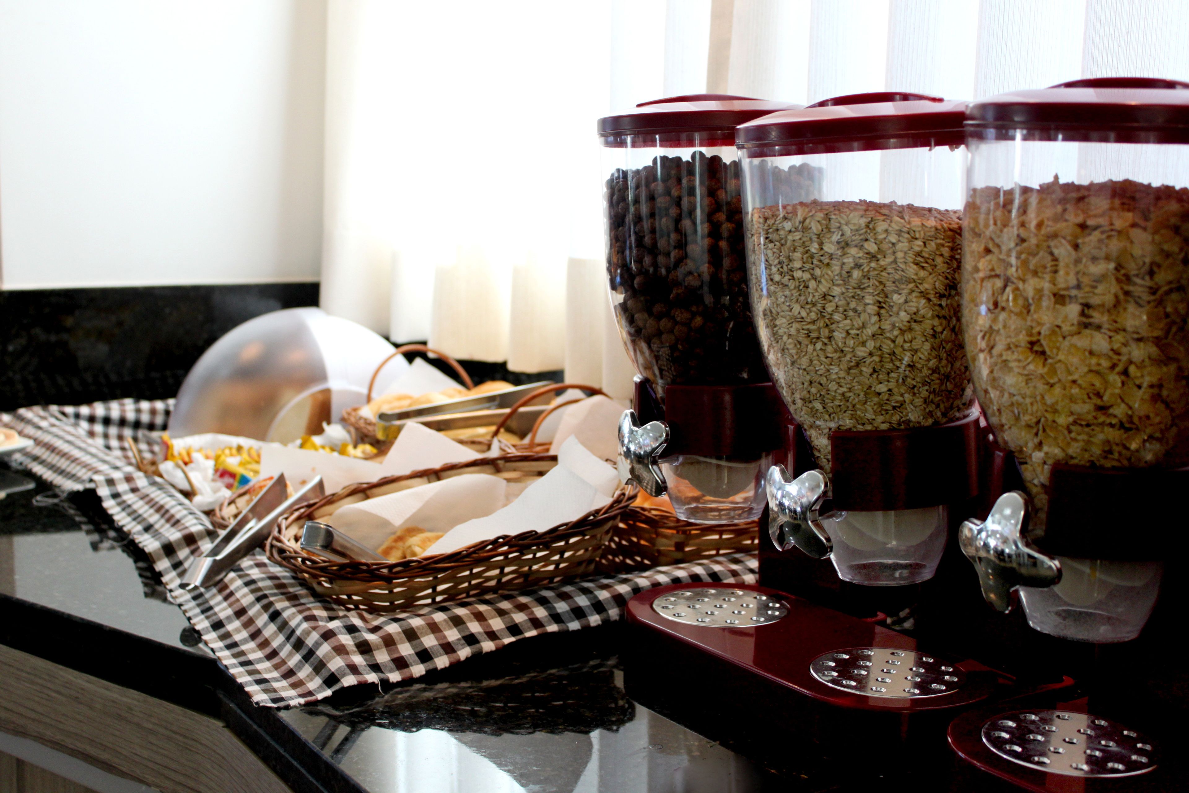 A breakfast buffet setup with various food containers and serving utensils.