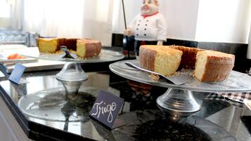 Una exhibición de postres con un letrero que dice "Frigo" y una figurita de chef al fondo.