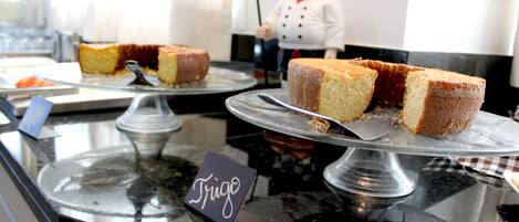 A dessert display with a sign reading "Frigo" and a chef figurine in the background.