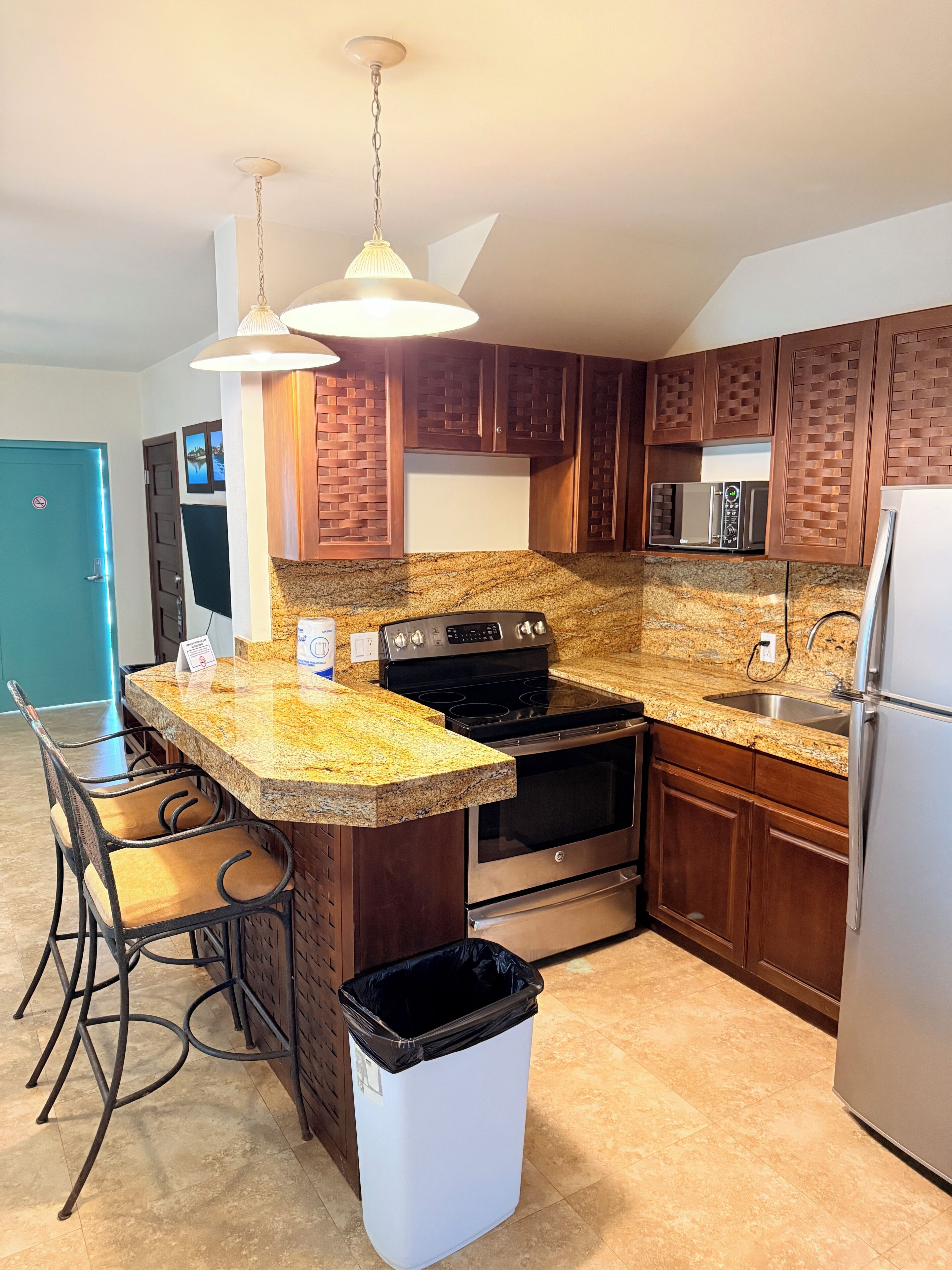A kitchen with granite countertops, stainless steel appliances, and wooden cabinets.