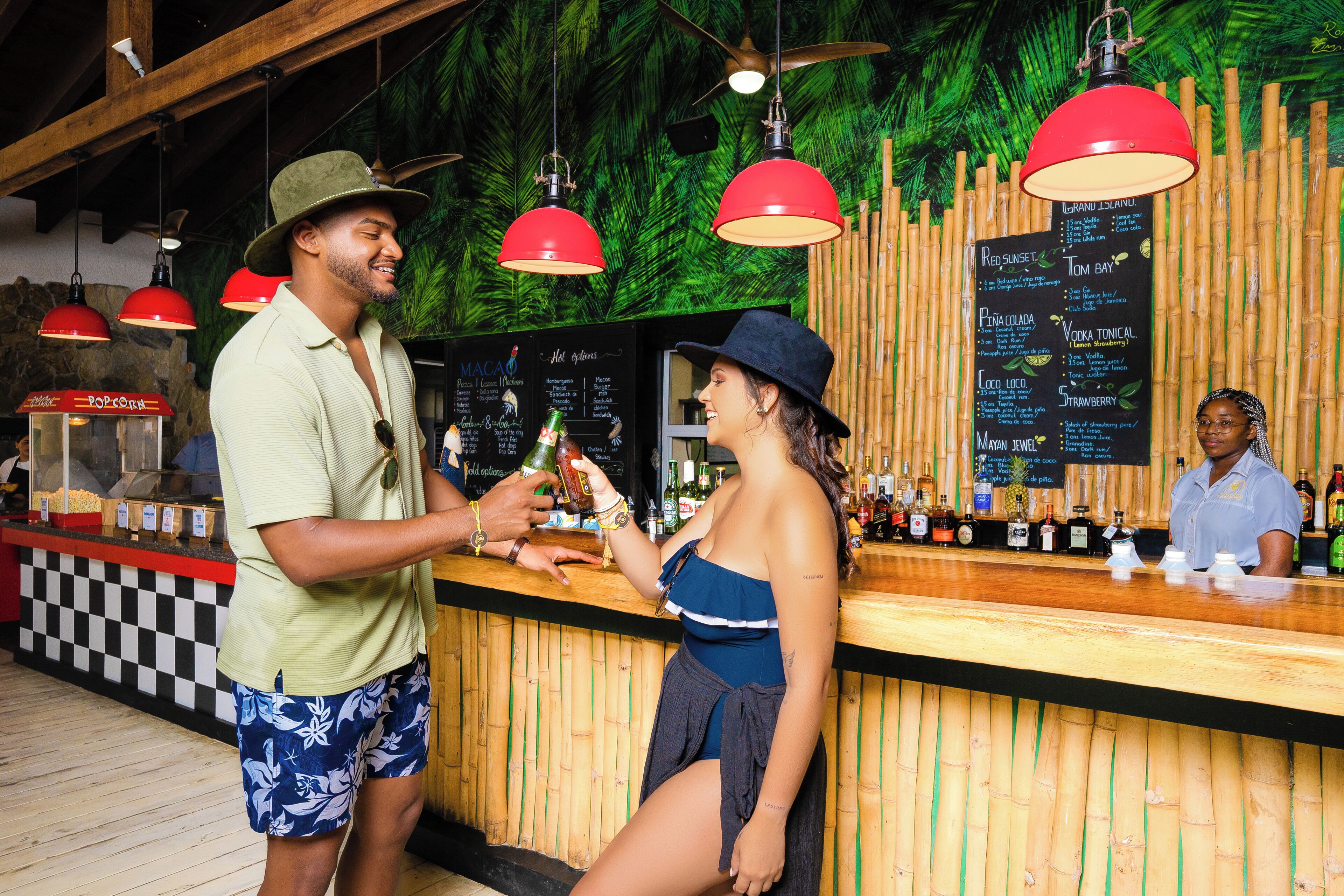 Un bar con mostrador de madera, luces colgantes rojas y una pizarra con el menú.