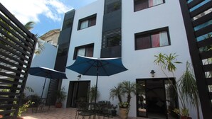 A courtyard with outdoor seating, potted plants, and umbrellas.
