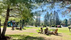A park with picnic tables, chairs, and a playground. - Saco River Motor Lodge & Suites (Center Conway)