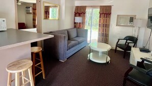 A compact living space with a kitchenette, a sofa, a dining table, and a TV. - Saco River Motor Lodge & Suites (Center Conway)