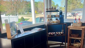 A reception desk with a view of the parking lot and trees outside. - Saco River Motor Lodge & Suites (Center Conway)