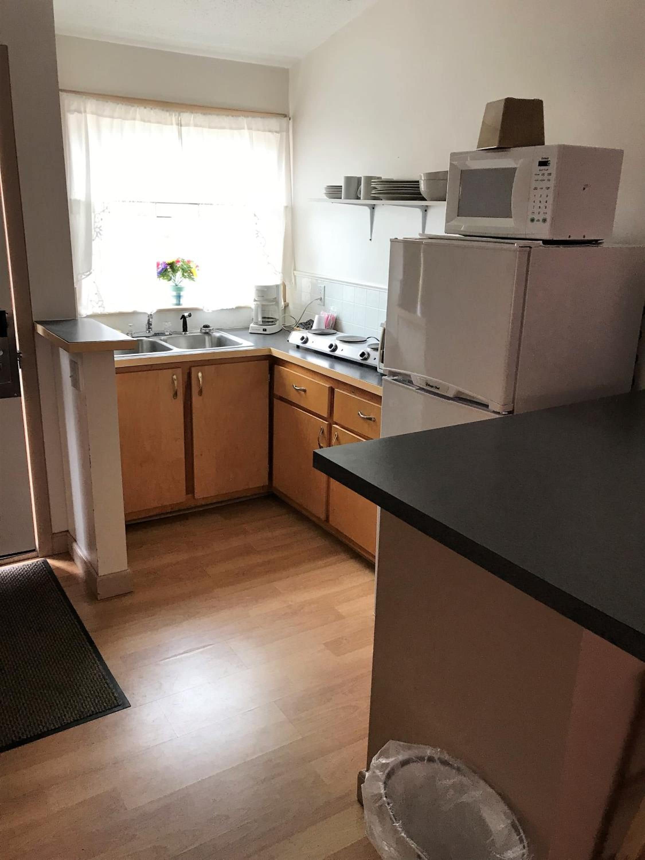 Cocina compacta con fregadero, estufa y microondas.