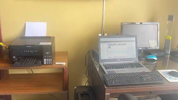 Un espacio de trabajo con escritorio, computadora, impresora y dos monitores.
