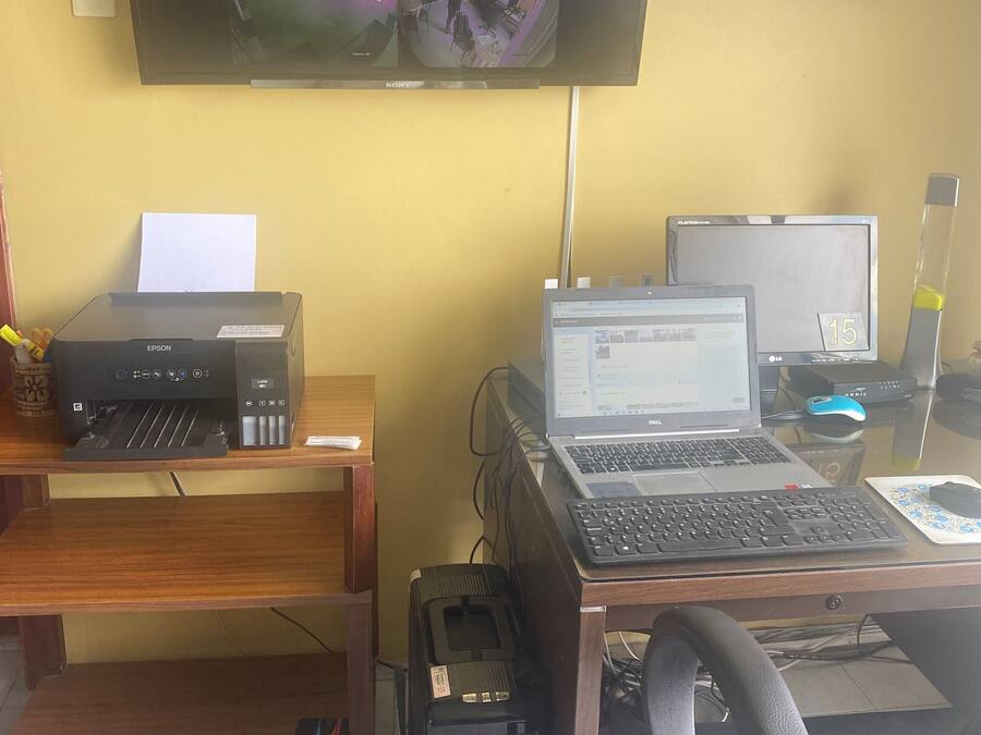 A workspace with a desk, computer, printer, and two monitors.