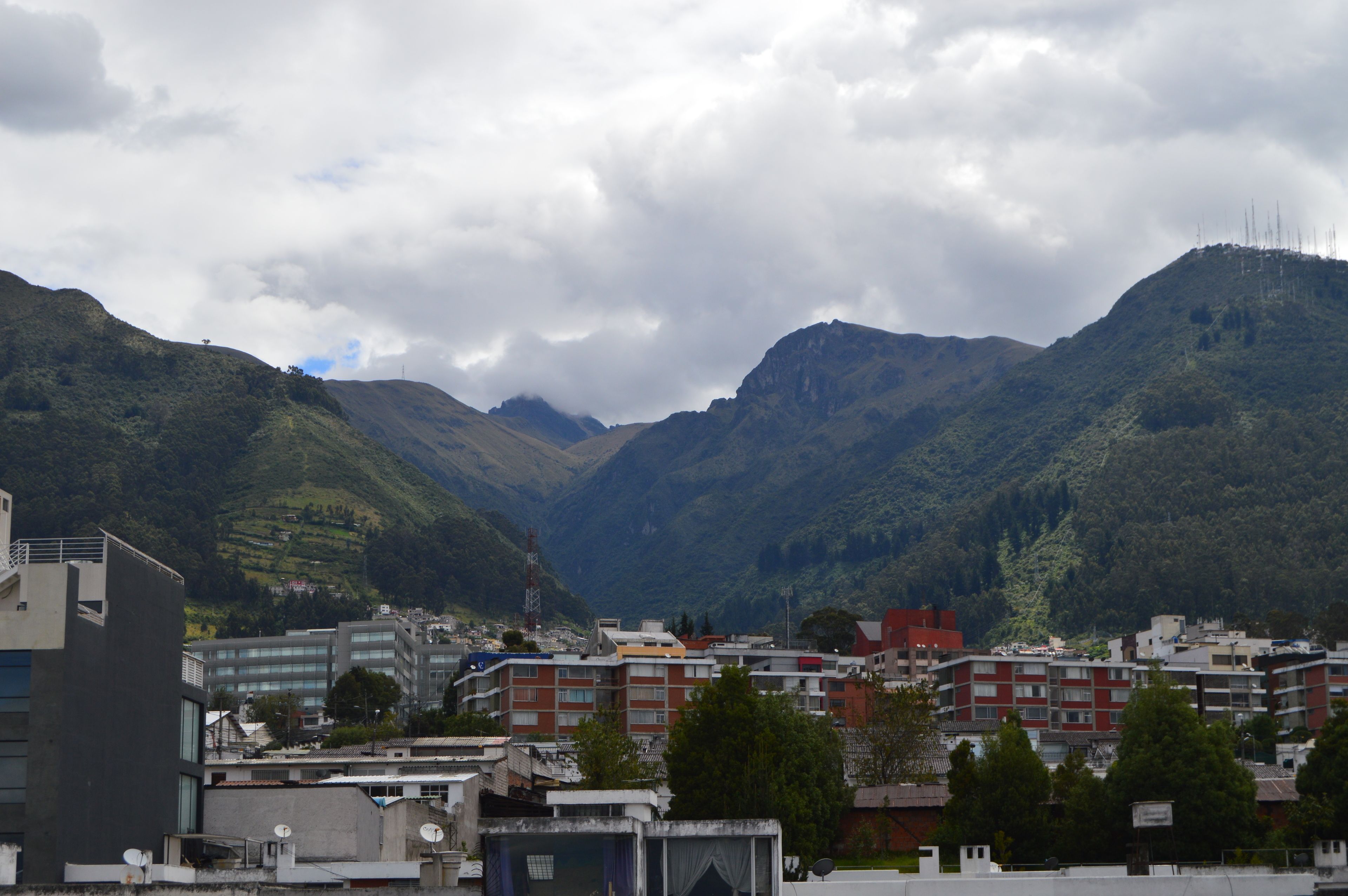 Un paisaje montañoso con edificios en primer plano.