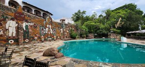 A swimming pool with stone tiles, surrounded by a mosaic wall and outdoor seating. - Hotel-Museo Posada de la Misón (Taxco)