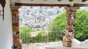 Una escalera de piedra que lleva a un balcón con vistas a un pueblo en la ladera de una colina.